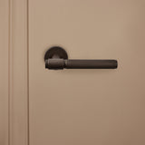 Lavuzo Cosenza brons Knurled deurbeslag gemonteerd op beige binnendeur, vooraanzicht