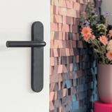 Oristano deurklink toegepast in een heel kleurrijk en vrolijk interieur. De zwarte deurklink op schild geeft contrast