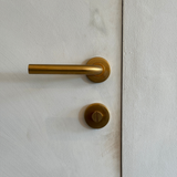 Zeer luxe toiletsluiting in het mat goud. Hier toegepast op een met kalkverf bewerkte deur