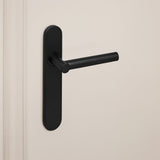 Mat zwarte Grosetto deurkruk van Lavuzo met afgerond schild op crèmekleurige deur, linkeraanzicht