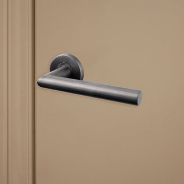 Gun Metal PVD gecoate Mantua deurklink op rond rozet op beige binnendeur, rechteraanzicht