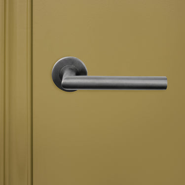 Lavuzo Mantua deurklink Gunmetal PVD met rond rozet op groene binnendeur, vooraanzicht