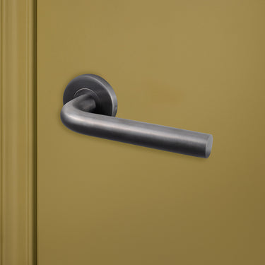 Luxe Oristano binnendeurbeslag Gun Metal PVD gecoat op groene deur, rechteraanzicht
