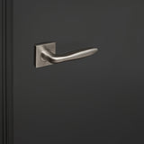 RVS Lavuzo Pratona deurgreep met vierkant rozet op een zwarte deur, linkeraanzicht